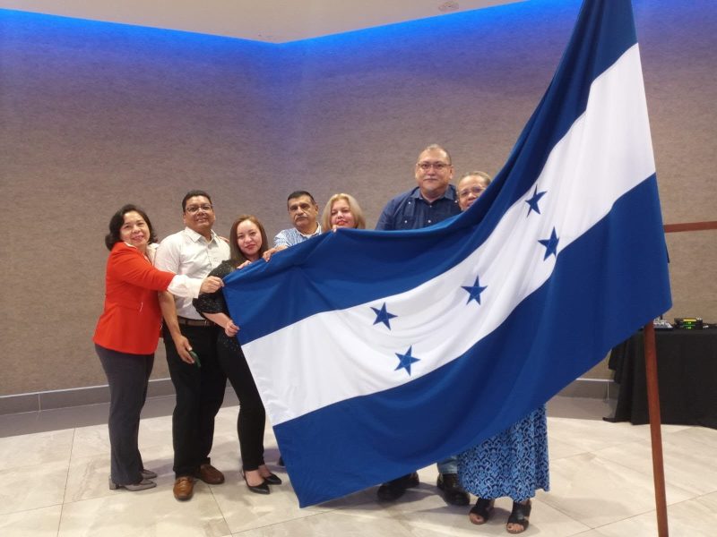 Miembros del Comité de Inversiones Permanentes del COHPUCP Zona Norte sosteniendo la bandera de Honduras