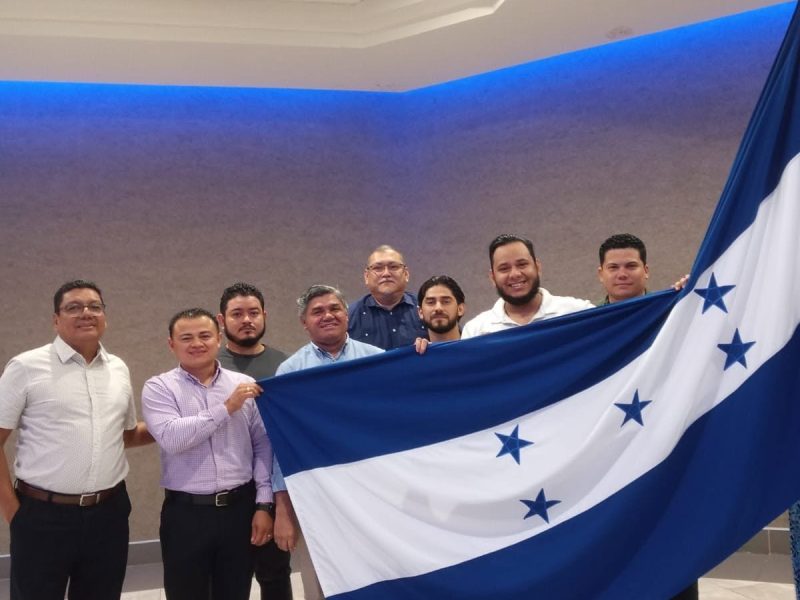 Miembros del Comité de Crecimiento y Expansión del COHPUCP Zona Norte sosteniendo la bandera de Honduras
